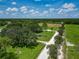 An aerial view of sprawling acreage featuring a pond, pastures, and mature trees at 26147 L And J Rd, Myakka City, FL 34251