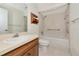 Bathroom featuring wood cabinets, a soaking tub with grab bars, and white tiling at 26147 L And J Rd, Myakka City, FL 34251