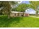 Charming single-story home with well-maintained lawn, mature trees, a metal roof, and a two car garage at 26147 L And J Rd, Myakka City, FL 34251