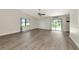 Spacious room with light gray wood-look flooring, large windows, and sliding door to yard at 26147 L And J Rd, Myakka City, FL 34251