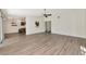 Open floor plan featuring light gray wood-look flooring, kitchen pass-through, and sliding doors to the yard at 26147 L And J Rd, Myakka City, FL 34251