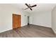 Bright main bedroom with wood flooring, ceiling fan, closet, and plenty of space for furniture at 26147 L And J Rd, Myakka City, FL 34251