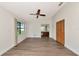 Bright main bedroom with wood flooring, a ceiling fan, a closet, and an en-suite bathroom featuring wood cabinets at 26147 L And J Rd, Myakka City, FL 34251