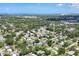 Aerial view of a residential neighborhood with lush green trees and houses with the ocean in the background at 2866 E Rainbow Cir, Sarasota, FL 34231