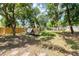 Backyard featuring mature trees, a wooden fence, and a play structure, creating a charming outdoor space at 2866 E Rainbow Cir, Sarasota, FL 34231