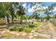 Large backyard featuring mature trees, lush garden, and fenced perimeter, ideal for outdoor activities at 2866 E Rainbow Cir, Sarasota, FL 34231