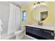 Bathroom with navy vanity, quartz countertop, gold fixtures, and shower with tub at 2866 E Rainbow Cir, Sarasota, FL 34231