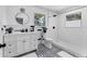Bright bathroom features a vanity with a white countertop and decorative black-and-white patterned floor at 2866 E Rainbow Cir, Sarasota, FL 34231