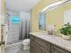 Modern bathroom with a glass-enclosed shower, a light countertop, and updated fixtures and finishes at 2866 E Rainbow Cir, Sarasota, FL 34231