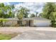 Inviting single-story home with lush greenery, a well-manicured lawn, and a convenient attached garage at 2866 E Rainbow Cir, Sarasota, FL 34231