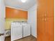 Bright laundry room with a washer, dryer, and orange storage cabinets at 2866 E Rainbow Cir, Sarasota, FL 34231