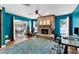 Living room with stone fireplace, ceiling fan, glass door, and a blue accent wall at 2866 E Rainbow Cir, Sarasota, FL 34231