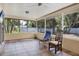 Screened patio with tile flooring, comfortable seating, and lush backyard views at 2866 E Rainbow Cir, Sarasota, FL 34231