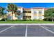 A view of the exterior of a multi-Gathering building with ample parking and landscaping at 3005 Chianti Ct # 103, Sarasota, FL 34237