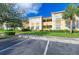 Multi-Gathering building featuring well-manicured lawn, trees, and paved parking at 3005 Chianti Ct # 103, Sarasota, FL 34237