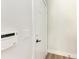 Hallway view showcases a white door with black hardware, a light switch, and an alarm panel at 3005 Chianti Ct # 103, Sarasota, FL 34237