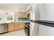 Kitchen featuring stainless steel appliances, light wood cabinets, and blue backsplash at 3005 Chianti Ct # 103, Sarasota, FL 34237
