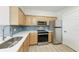 Bright kitchen features stainless steel appliances, wood cabinetry, and vinyl flooring at 3005 Chianti Ct # 103, Sarasota, FL 34237