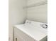 This laundry area contains a white front load washing machine and wire shelving at 3005 Chianti Ct # 103, Sarasota, FL 34237