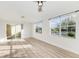 Bright living room with new laminate flooring, ceiling fan, and two large windows at 3005 Chianti Ct # 103, Sarasota, FL 34237