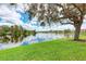 A tranquil pond surrounded by manicured lawns, trees, and residential buildings at 3005 Chianti Ct # 103, Sarasota, FL 34237