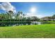 Scenic view of a well-manicured lawn sloping down to a pond with a fountain at 3005 Chianti Ct # 103, Sarasota, FL 34237