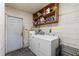 Laundry room with white washing machine, dryer, and storage shelves at 3211 Deerfield Dr, Tampa, FL 33619