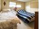 Bedroom with two beds, wood-look walls, and window with blinds at 3224 Aspen Ter, Sarasota, FL 34237