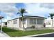 Cozy single-story home showcasing neat landscaping, large windows, and durable siding, surrounded by a lush green lawn at 3224 Aspen Ter, Sarasota, FL 34237