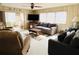 Comfortable living room with a large TV, a modern sofa, and natural light, perfect for relaxation and entertainment at 3224 Aspen Ter, Sarasota, FL 34237