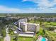 Aerial view of condominium complex, golf course, and pool surrounded by greenery at 3680 Ironwood Circle # 704-L, Bradenton, FL 34209