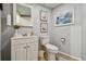 A bright, traditionally decorated bathroom with vanity, toilet and palm tree artwork at 3680 Ironwood Circle # 704-L, Bradenton, FL 34209