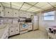 Practical kitchen featuring white cabinets, vintage appliances, and window at 3680 Ironwood Circle # 704-L, Bradenton, FL 34209
