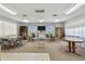 Bright recreation room featuring carpeted floor, tables, chairs, shelving, and a television screen at 3680 Ironwood Circle # 704-L, Bradenton, FL 34209