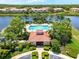 Aerial view of community pool, clubhouse, lake, and residential buildings surrounded by mature landscaping at 3698 Parkridge Cir # 26-104, Sarasota, FL 34243
