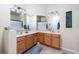 Bathroom featuring a double sink vanity with wood cabinets and a shower with blue accents at 3698 Parkridge Cir # 26-104, Sarasota, FL 34243