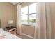 A bedroom with a lake view featuring a large window with white curtains at 3698 Parkridge Cir # 26-104, Sarasota, FL 34243