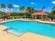Community pool with blue water, lounge chairs, shade structures, and palm trees at 3698 Parkridge Cir # 26-104, Sarasota, FL 34243