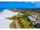 Breathtaking aerial view of a beachfront property with lush vegetation, white sand, and azure blue ocean at 3959 Somerset Dr # 5, Sarasota, FL 34242