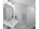 Modern bathroom featuring a pedestal sink with decorative mirror and hardware, and stylish walk-in shower at 3959 Somerset Dr # 5, Sarasota, FL 34242