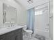 Bright bathroom features a shower/tub combo, sleek vanity with modern fixtures, and stylish blue striped shower curtain at 3959 Somerset Dr # 5, Sarasota, FL 34242