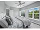 Comfortable bedroom features a plush bed, ceiling fan, and views of neighborhood from large windows with shutters at 3959 Somerset Dr # 5, Sarasota, FL 34242