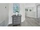 Hallway features wood-look tile flooring, a gray dresser, and view of the room with blue and white floral decoration at 3959 Somerset Dr # 5, Sarasota, FL 34242