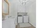 Well-lit laundry room features a modern washer and dryer, ample cabinet storage, and a stylish vanity area at 3959 Somerset Dr # 5, Sarasota, FL 34242