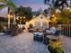 Inviting outdoor patio features stylish seating, brick pavers, and ambient string lights for relaxed evenings at 3959 Somerset Dr # 5, Sarasota, FL 34242