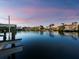 Stunning waterfront view with a private dock, boat lift and serene water reflecting the evening sky at 3959 Somerset Dr # 5, Sarasota, FL 34242