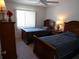 Comfortable bedroom featuring two beds, a ceiling fan, and a nightstand with a decorative lamp at 4016 Oakview Dr # J6, Punta Gorda, FL 33980