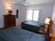 Well-lit bedroom with two beds, a dresser, and a window with blinds at 4016 Oakview Dr # J6, Punta Gorda, FL 33980