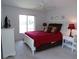 Comfortable bedroom featuring a red bedspread, white furniture, and soft lighting at 4016 Oakview Dr # J6, Punta Gorda, FL 33980