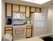 Well-lit kitchen equipped with essential appliances, including a microwave, range, and refrigerator at 4016 Oakview Dr # J6, Punta Gorda, FL 33980